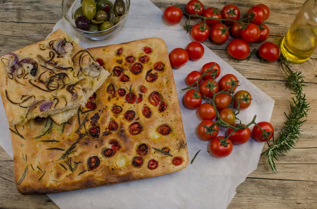 Slices of focaccia stuffed and garnished with cherry tomatoes, onion and rosemary./Getty Images